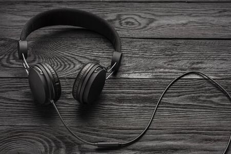 The headphones are dark in color against a wooden wall..の写真素材