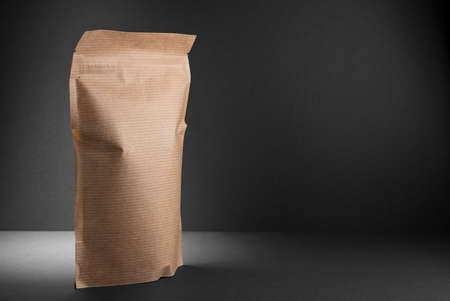 eco-friendly packaging, the package is isolated on a dark background. Copy space. Black paper...