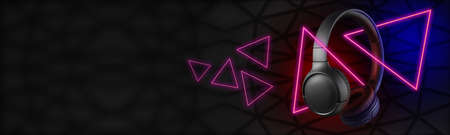 Wireless black headphones on a dark background with glowing triangles.の写真素材