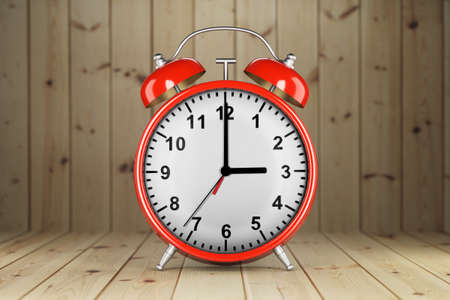 Red alarm clock on a wooden background. Front view. 3d render.の写真素材