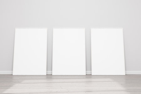 Models of paintings, posters, photographs. Three empty wooden frames for a photo or picture on the floor near a white wall. Design template for layout. 3D rendering.の写真素材