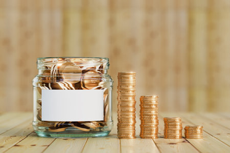 A glass jar filled with gold coins symbolizing financial savings, wealth accumulation, and smart money management. An emergency jar filled with coins symbolizing financial security. 3d renderの写真素材