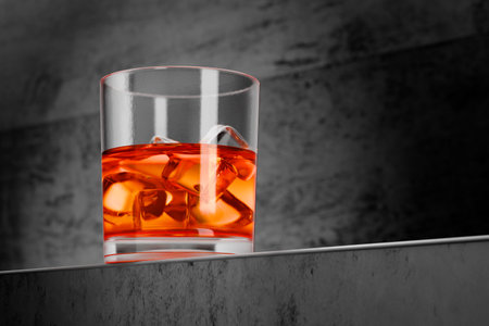 Glass of whiskey with ice on a concrete table. Whiskey on the table. Glass of cold whiskey on the bar counter. 3d render.の写真素材