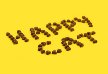 text from animal feed. text happy cat. eat for animals. yellow background. High quality photo