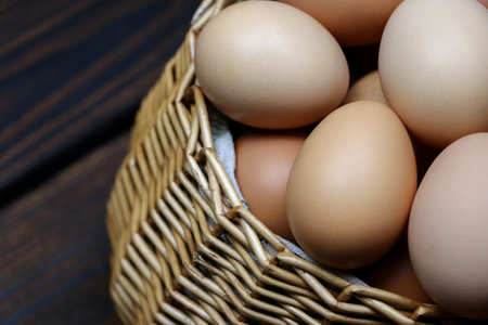 wicker straw basket with eggs on wooden background. High quality photoの写真素材