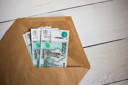 banknotes of Rubles in an envelope on a wooden tableの写真素材