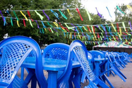 empty blue plastic chairs and tables outside, preparing for the holiday, no people
