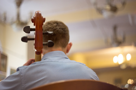 close up of a man playing the cello, a real concert, rear viewの写真素材