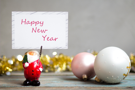 Santa Claus holding blank greeting card and Christmas decoration on wooden tableの写真素材