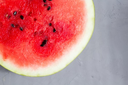 top view of half of juicy watermelon on the grey backgroundの写真素材