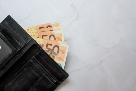 banknotes 50 euros in a man's leather purse on the marble background. Top view Men's wallet with cash euro.の写真素材
