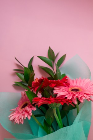 bouquet of pink and red gerberas on a pink pastel backgroundの写真素材