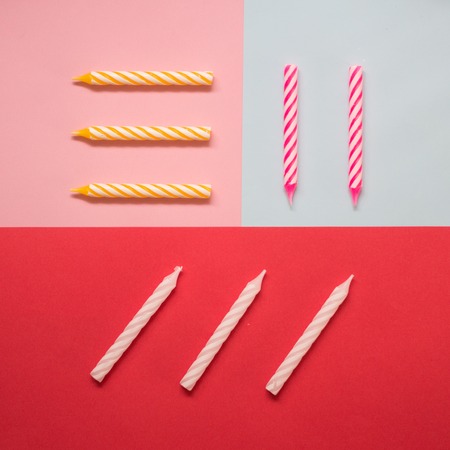Multi-colored striped candles for birthday on the pastel colored background. Minimalism. Flat lay.の写真素材