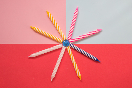 Multi-colored striped candles for birthday on the pastel colored background. Minimalism. Flat lay.の写真素材