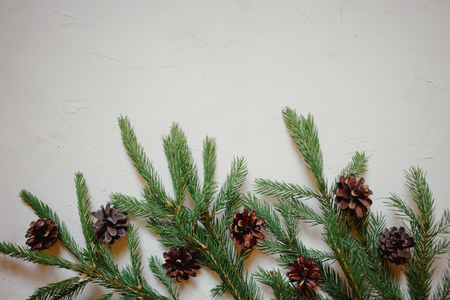 Christmas background with fir tree and decor, branches and cones. Top view with copy space, white plastered backgroundの写真素材