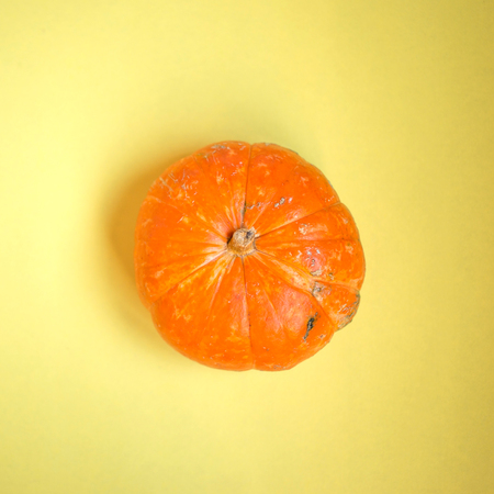 Top view a pumpkin on the yellow backgroundの写真素材