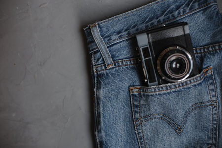 Moscow, Russia - 08 30 2018:top view blue jeans, vintage retro camera in pocket, copy spaceの写真素材