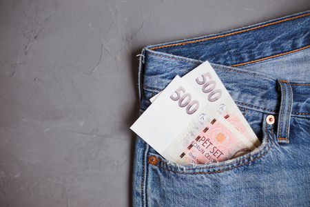 Moscow, Russia - 08 30 2018: Money financial concept. Czech crown banknotes in a pocket of blue jeans on gray background.の写真素材