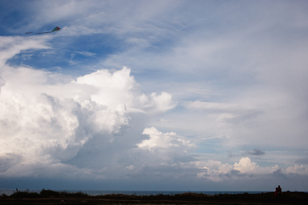 kite and Cumulus clouds and sun in the skyの写真素材