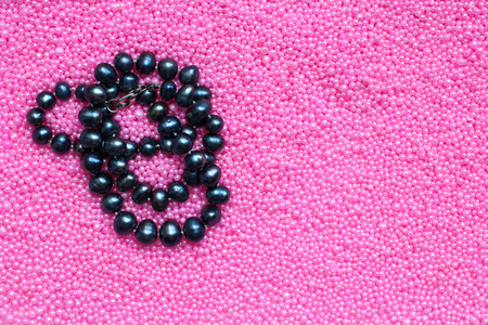 black pearl beads on pink background, copy spaceの写真素材