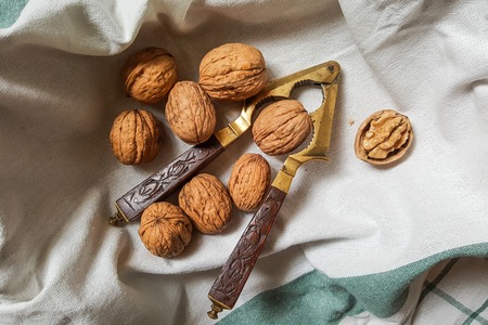 walnuts and vintage nutcracker with carved wooden handleの写真素材