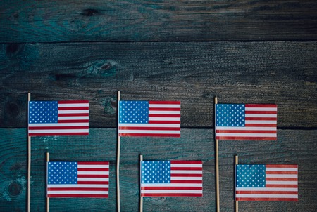 Miniature paper flag USA. American Flag on rustic wooden background.の写真素材