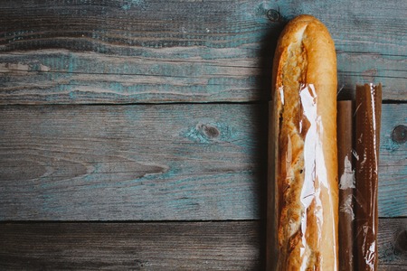 Fresh bread baguette on wooden table. Top view with space for your textの写真素材