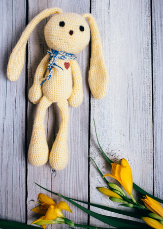 Moscow, Russia: toy hare with a bouquet of lilies on a wooden background, a gift for a babyの写真素材