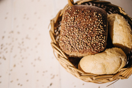 Assortment of baked bread on white wooden table background, hard lightの写真素材
