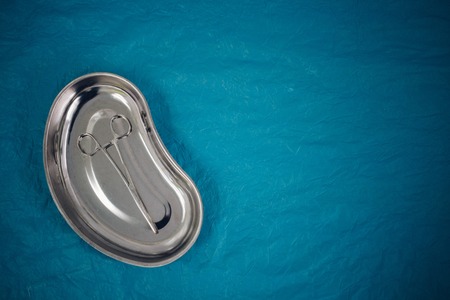 top view of medical instruments in the tray, disposable gloves on blue background. health, longevityの写真素材