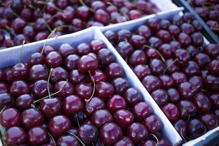 boxes with fresh red cherries, counter of the seller of fruit and vegetables, farmer's marketの写真素材