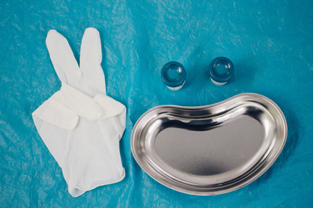 medical tray, disposable gloves showing the peace sign, jars for taking biomaterial lined in the form of a smiling face. health, longevity,の写真素材
