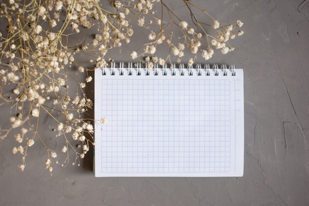 empty notebook and dry flower on gray background. copy space.の写真素材