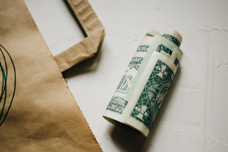 Cash dollars money, with a Kraft package on white background.の写真素材