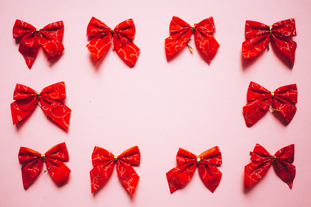 Christmas red satin bows frame, ribbons on pink background. Copy spaceの写真素材