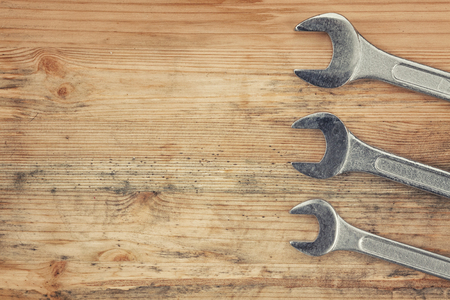Three wrenches on an old woodの写真素材