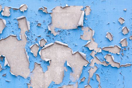 Old concrete wall with blue cracked paintの写真素材