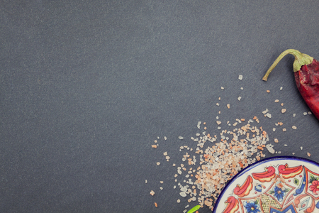 Oriental stillife with pepper, garlic and pink salt on a stone boardの写真素材