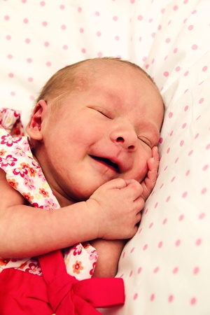 Sleeping and smiling cute and funny baby girlの写真素材