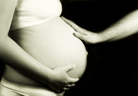 Father and mother holding pregnant belly. Concept of support and safety.の写真素材