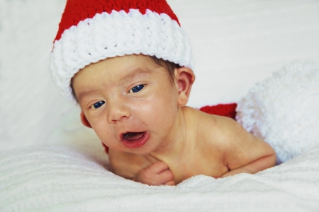 Cute new born baby boy in bed with santa claus hatの写真素材