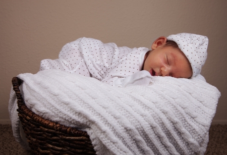 Newborn baby boy with pajamas sleeping comfortable in the basketの写真素材