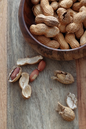 Peanuts with shell on a wooden background