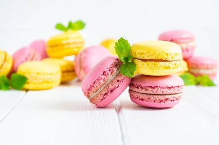 Colorful macaroons and mint leaves on white wooden background.の写真素材