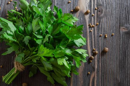 Bunch of fresh parsley and spices on dark wooden background.の写真素材