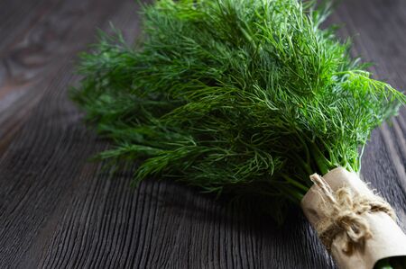Bunch of fresh dill and spices on dark wooden background.の写真素材