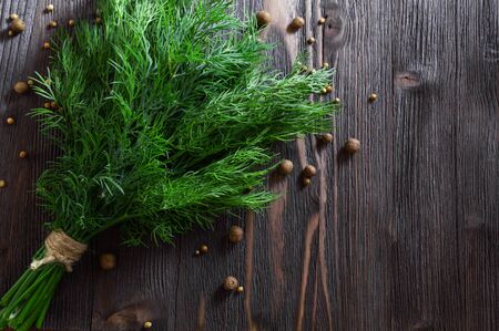 Bunch of fresh dill and spices on dark wooden background. Flat-lay, top view.の写真素材