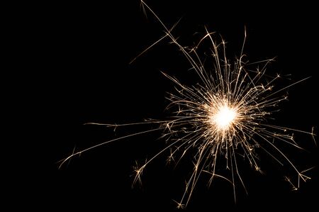 One small new year sparkler on black background.の写真素材