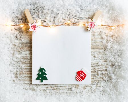 Christmas layout made of snow, Christmas lights and paper card note. Flat lay. New Year or Christmas concept.の写真素材