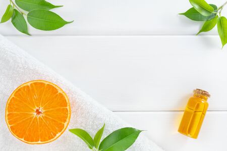 Natural, SPA or homemade cosmetics concept with orange fruits on white wooden background. Top view with copy space.の写真素材
